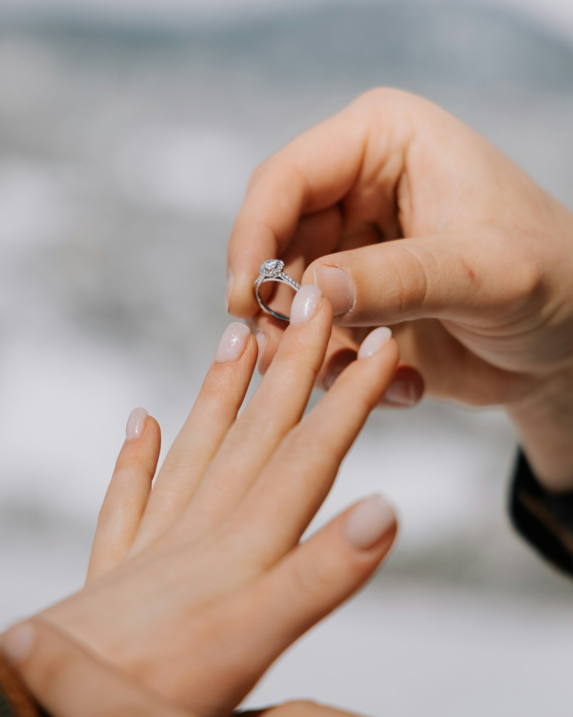 A man slipping a ring onto his partner's finger