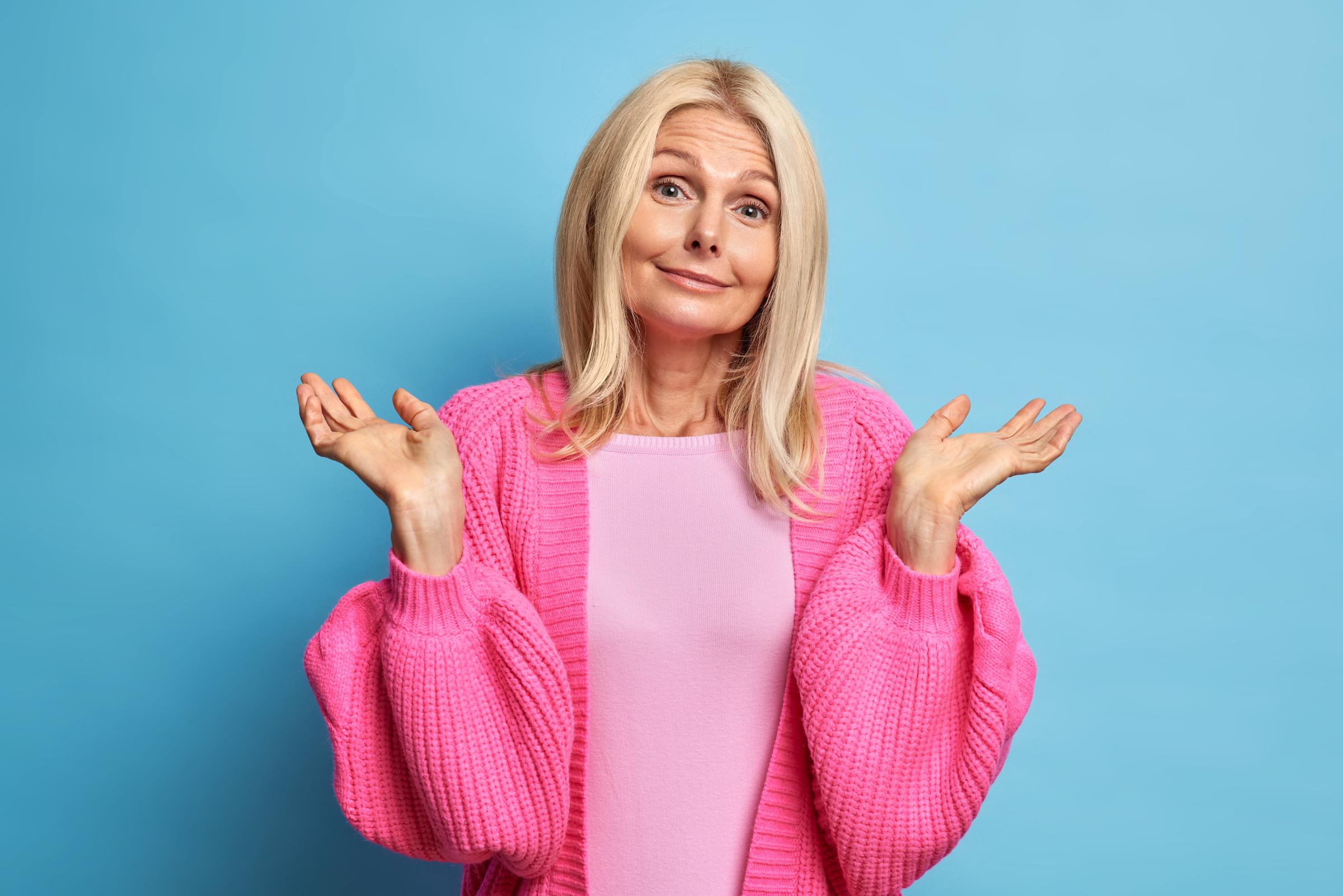 A senior woman shrugging with indifference
