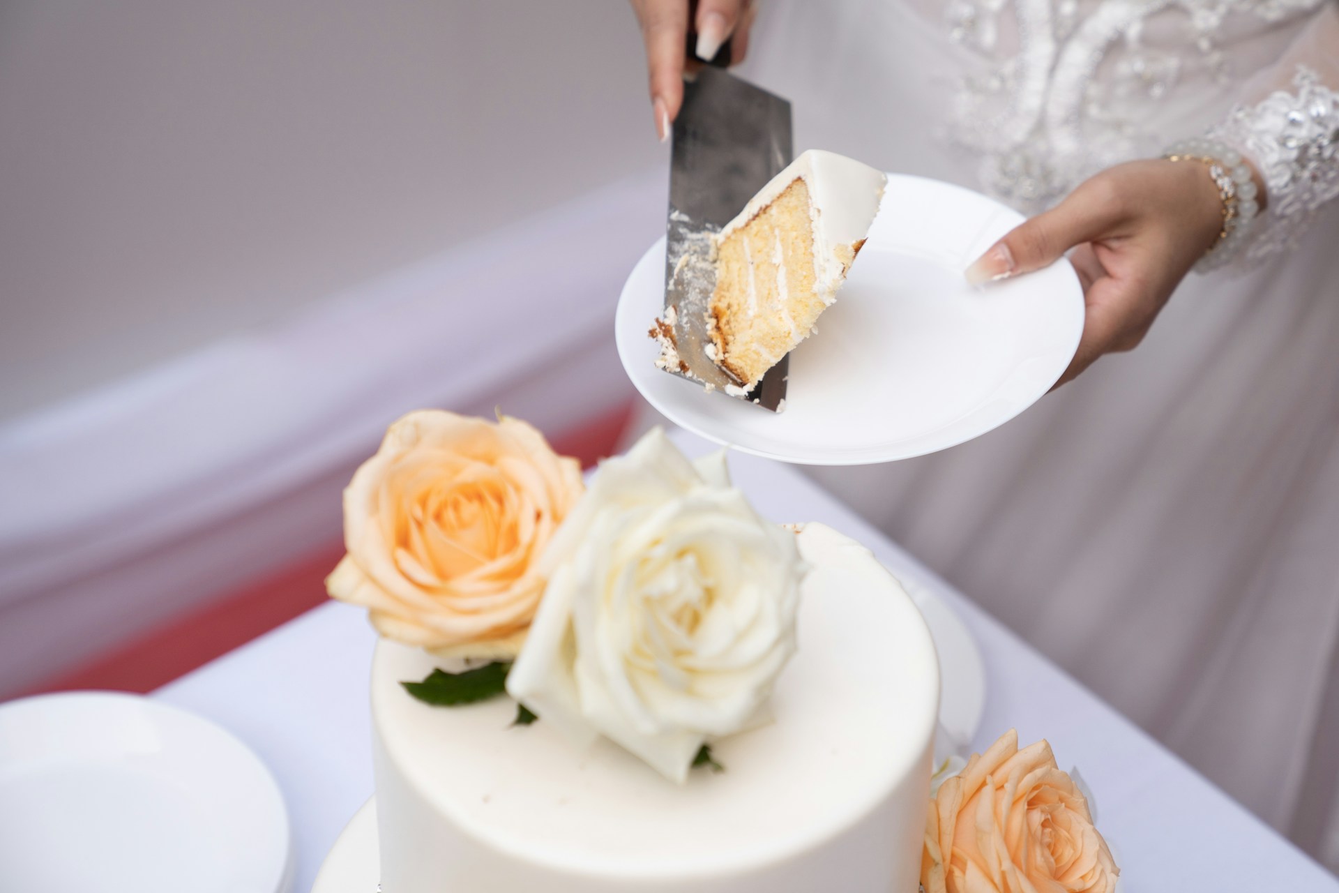 A bride holding a plate of wedding cake