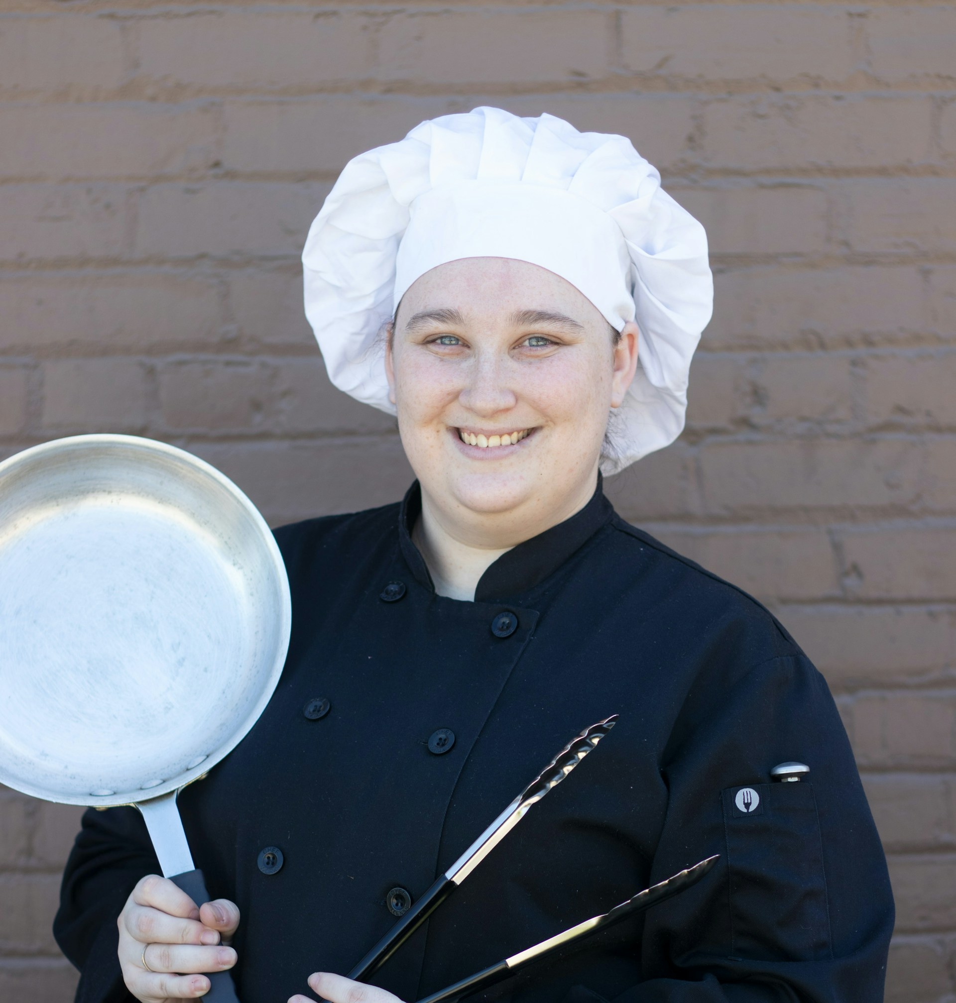 A female chef holding cookware